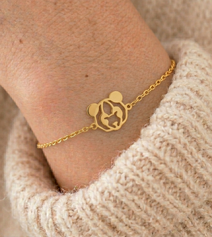 Bracelet animal totem panda doré porté au poignet avec un pull en maille – bijou symbolique femme inspiré du panda, symbole de paix, de douceur, d’équilibre intérieur et de force tranquille.