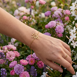 Bracelet animal totem girafe en or au design géométrique, fin bijou minimaliste porté par une femme dans un champ de fleurs printanières.