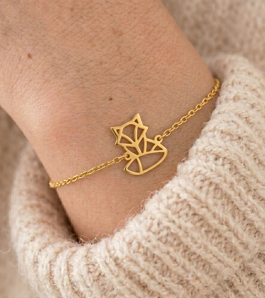 Bracelet animal totem renard doré porté au poignet avec un pull beige – bijou symbolique femme inspiré du renard, symbole d’intelligence, d’adaptabilité et de confiance en soi.
