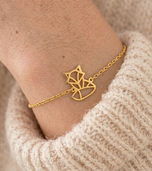 Bracelet animal totem renard doré porté au poignet avec un pull beige – bijou symbolique femme inspiré du renard, symbole d’intelligence, d’adaptabilité et de confiance en soi.