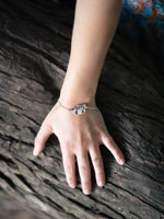 Bracelet panda roux en acier inoxydable au poignet d’une femme