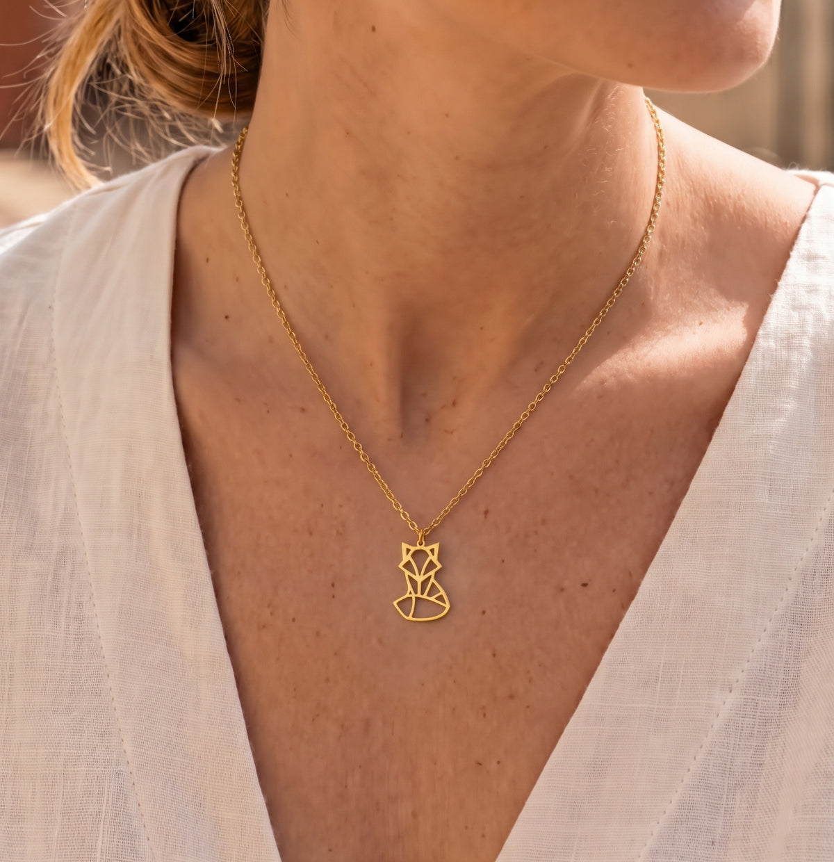 Femme portant un collier doré avec un pendentif renard au design géométrique en acier inoxydable par LIYAMI Nature