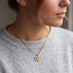 Collier animal totem éléphant porté par une femme sur un pull gris