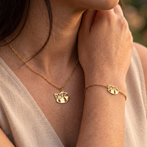 Duo de bijoux panda roux animal totem LIYAMI Nature : collier et bracelet dorés en acier inoxydable avec pendentifs panda roux géométrique, portés par une femme.