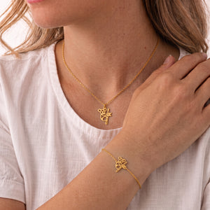 Parure de bijoux koala animal totem LIYAMI Nature : collier et bracelet dorés en acier inoxydable avec pendentifs koala géométrique, portés par une femme.