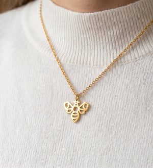 Femme portant un collier doré avec un pendentif abeille au design géométrique en acier inoxydable par LIYAMI Nature
